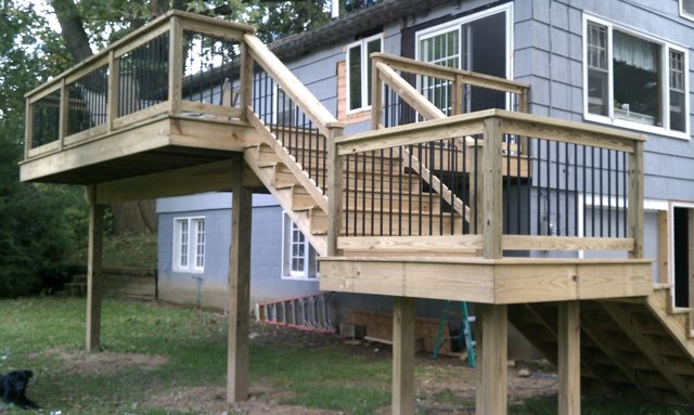 Natural wood, dark balusters, and a turning staircase connecting the home to the yard.