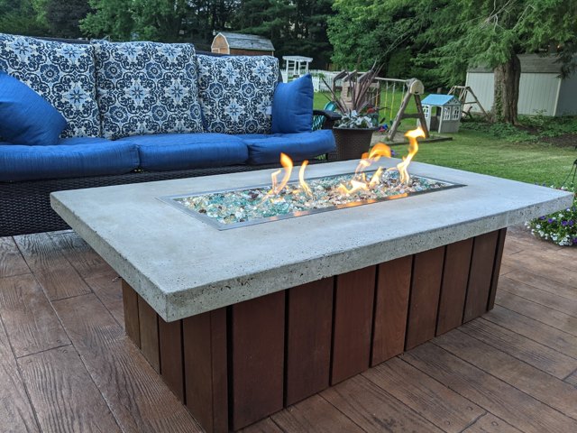 A low deck with outdoor seating and a central fire feature.