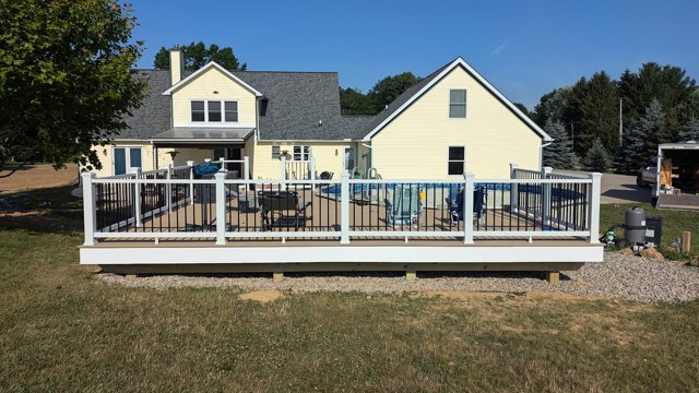 A long pool deck with contrasting white posts and dark balusters.