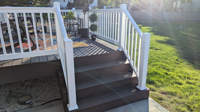 Warm-toned stair treads framed by white posts and railings.
