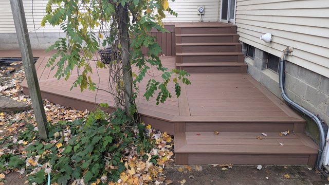 Matching stair and fascia details connect the levels beside the house.